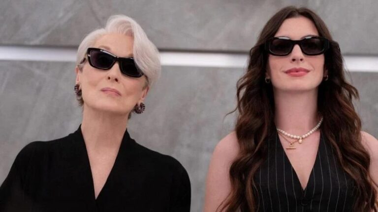 O Diabo Veste Prada 2: fotografia de divulgação do filme mostrando as personagens Miranda Priestly e Andy Sachs lado a lado, vestindo preto e de óculos escuros.