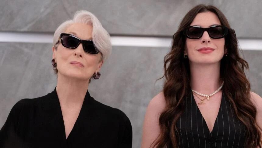 O Diabo Veste Prada 2: fotografia de divulgação do filme mostrando as personagens Miranda Priestly e Andy Sachs lado a lado, vestindo preto e de óculos escuros.